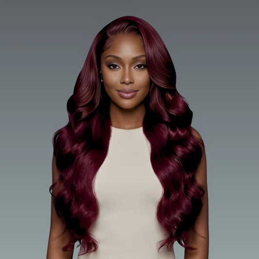 Woman with long, wavy burgundy hair against a gray background