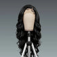 Black wig on a mannequin head against a gray background