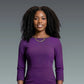 Woman wearing a purple dress against a gray background