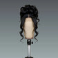 Black wavy wig on a mannequin head against a gray background