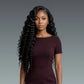 Woman with long, styled hair wearing a dark purple dress against a gray background