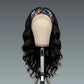 Black wavy wig on a mannequin head with a blue patterned headband against a gray background