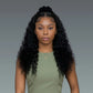 Woman with long, curly black hair wearing a green top against a gray background