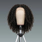Curly wig on a mannequin head against a gray background