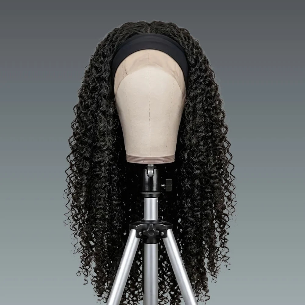 Black curly wig on a mannequin head with a gray background